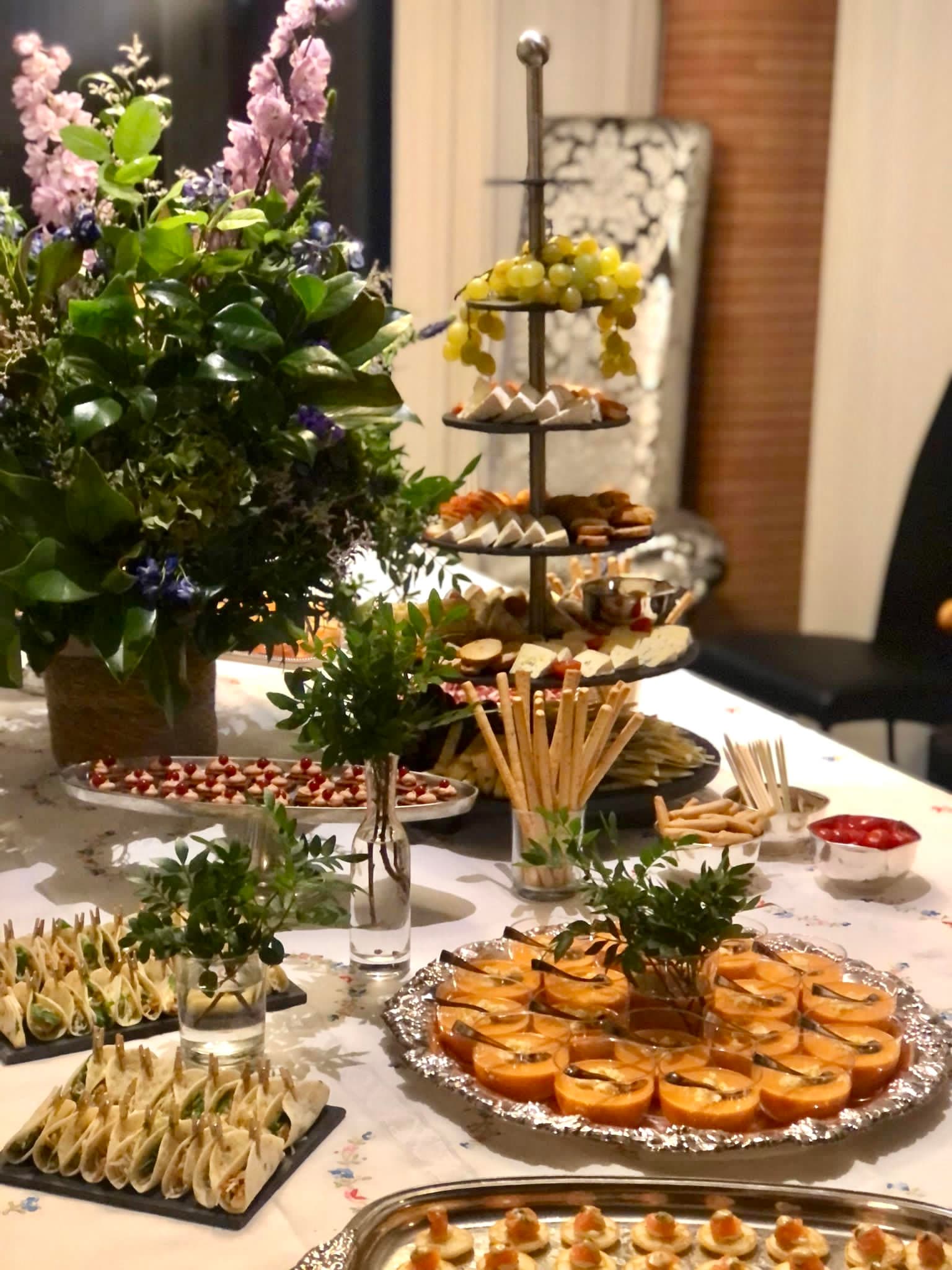 Buffet gourmet con canapes, flores y torre de aperitivos en celebracion privada en Madrid