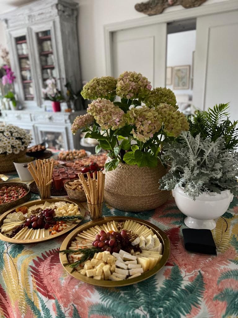 Mesa rustica con buffet de quesos, uvas y flores en catering para evento en Madrid